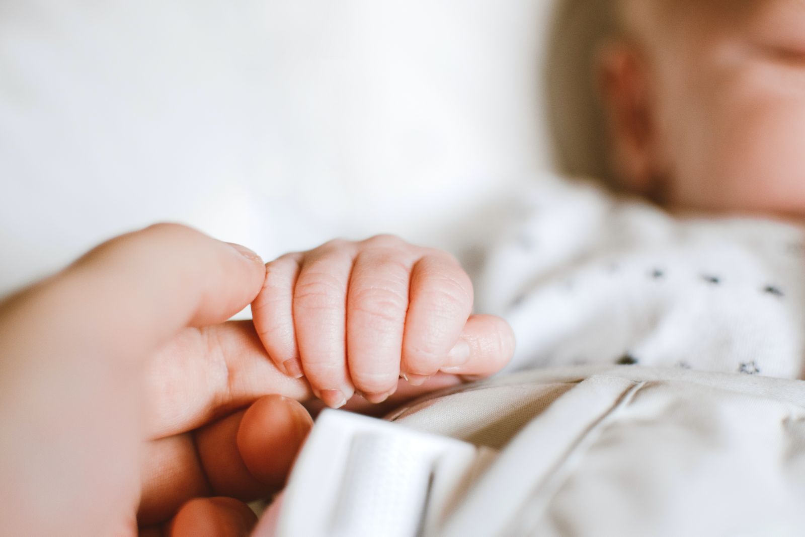 person holding an infant's hand